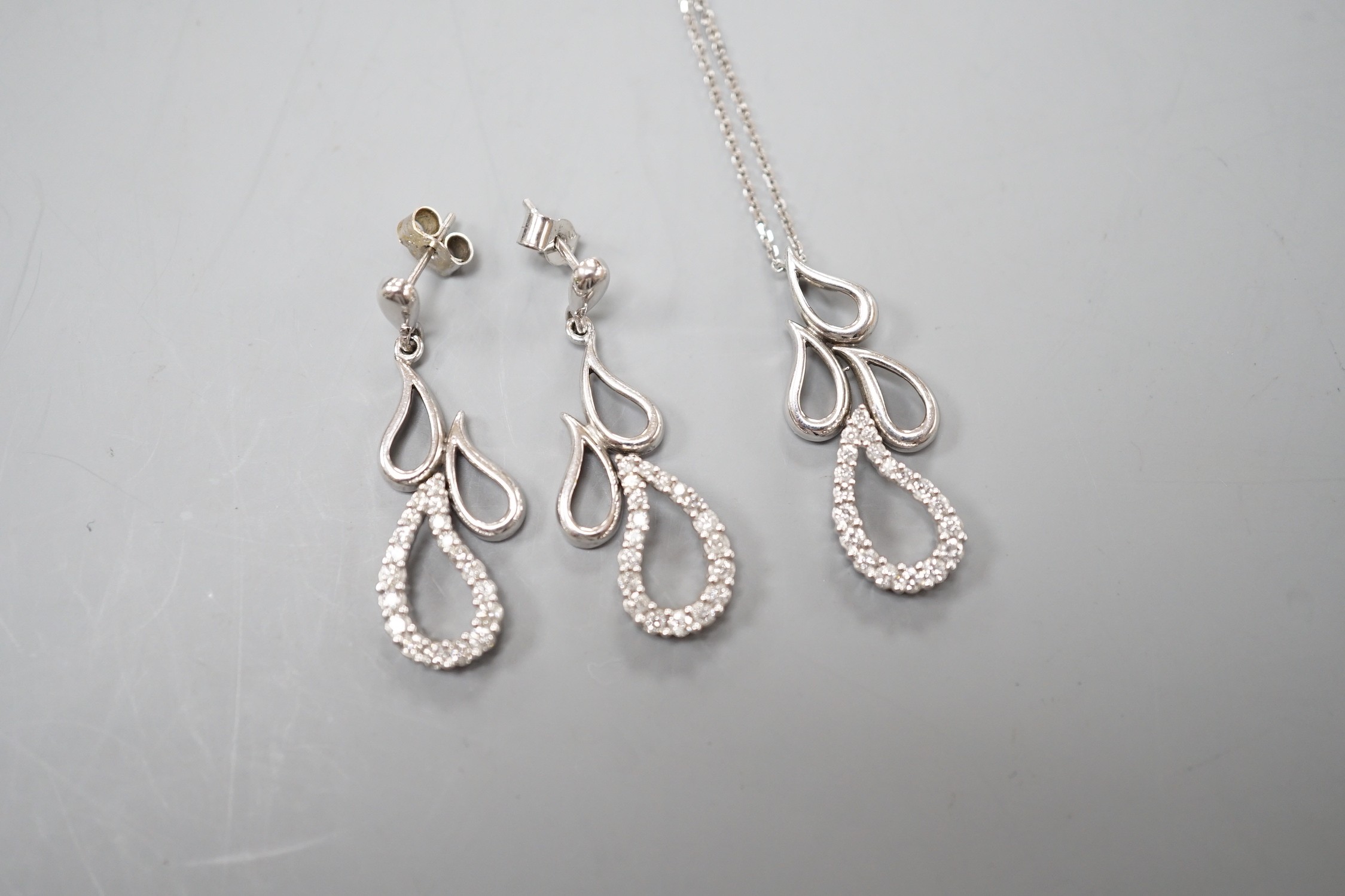 A modern white metal and diamond set quadruple teardrop shaped cluster drop pendant, 28mm, on a 9ct white gold fine link chain, 39cm and a pair of matching earrings, gross weight 7.6 grams.